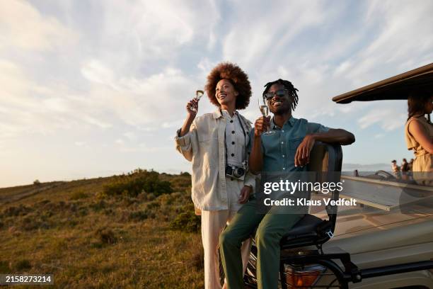happy young multiracial couple with champagne flutes - african flutes stock pictures, royalty-free photos & images