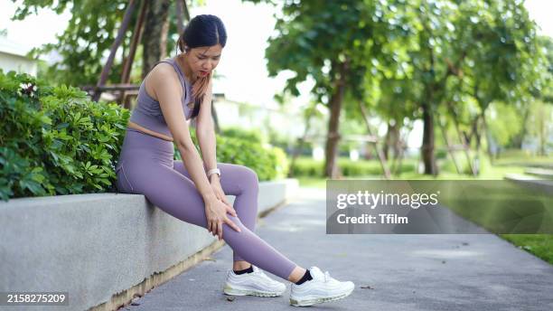 woman massaging sore leg after exercise - teen headache stock pictures, royalty-free photos & images