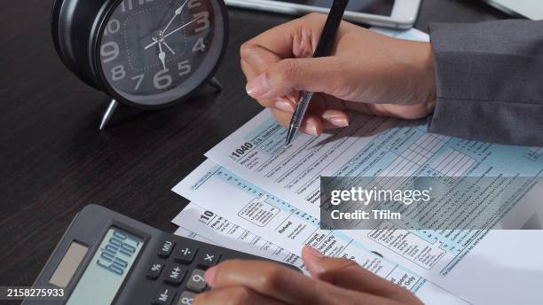 filling out tax forms with calculator - refund stock pictures, royalty-free photos & images