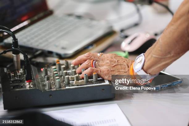 cropped hands senior woman working with sound mixer and doing dj set for outdoor summer party - sound engineer stock pictures, royalty-free photos & images