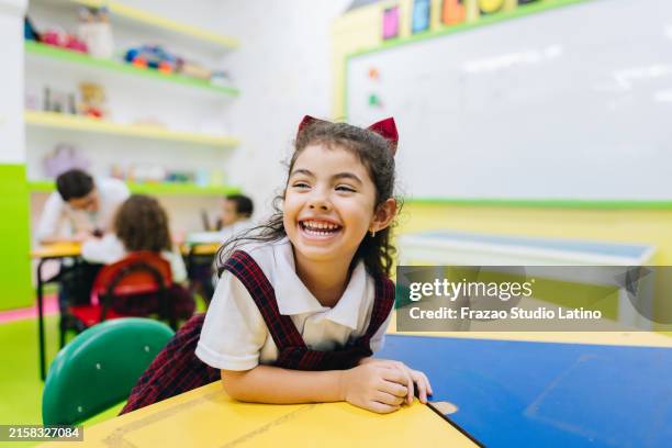 happy child girl in school classroom - alleen meisjes stockfoto's en -beelden