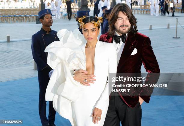 French designer Stephane Rolland poses with Indian entrepreneur Mona Patel during a photocall upon arrival to attend the Spring/Summer 2025 menswear...