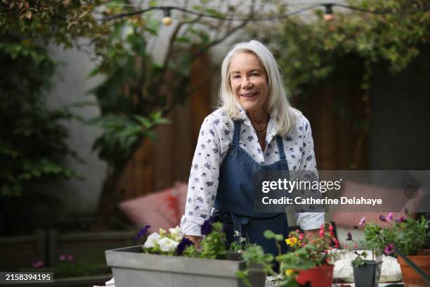 an elderly woman gardening on her balcony, at home - green thumb stock pictures, royalty-free photos & images