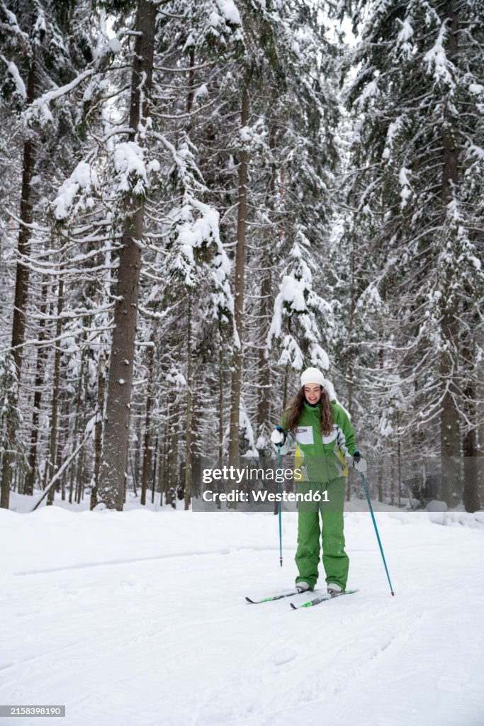 Woman skiing in winter at forest