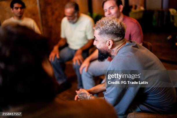 reifer mann spricht und wird in einer gruppentherapie in einem psychiatrischen zentrum getröstet - anonyme alkoholiker stock-fotos und bilder