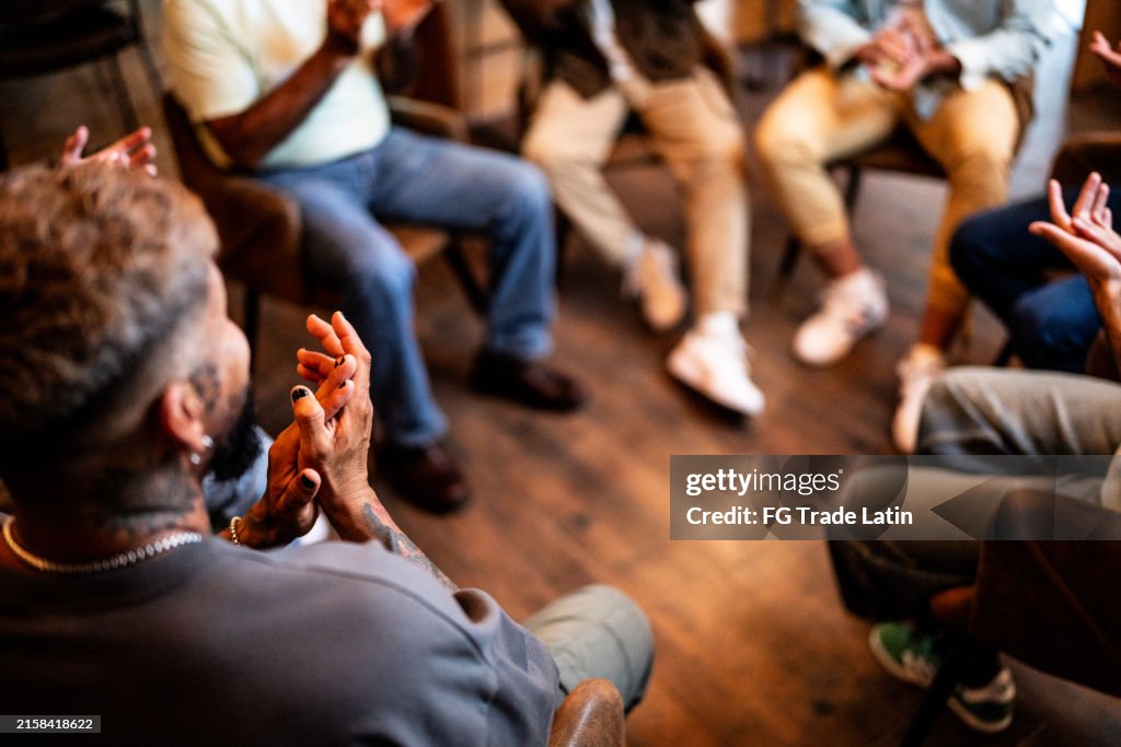 Men applauding in group therapy at mental health center