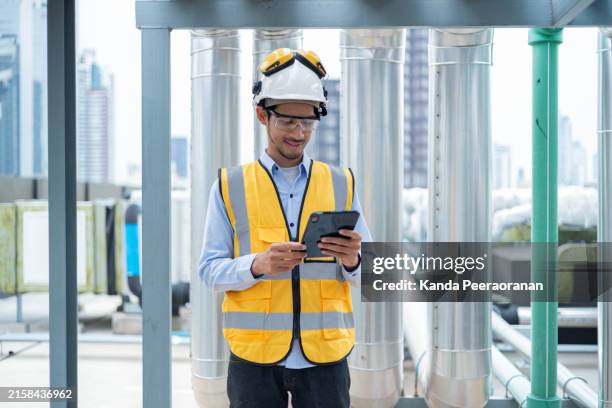 ingenieur prüft zeichnungen auf dem dach - pumps stock-fotos und bilder