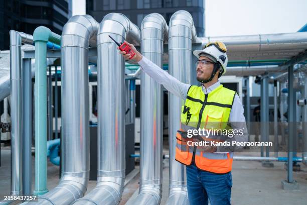 ingenieur unter überprüfung der industrie kaltwasser gebläse spule einheit klimaanlage ist wasserkühlung turm luftkühler hvac-system des großen industriegebäudes zur steuerung des luftsystems - pumps stock-fotos und bilder