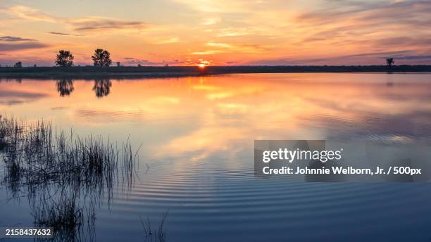 scenic view of lake against orange sky,th ave nw,united states,th ave,usa - canal interior imagens e fotografias de stock