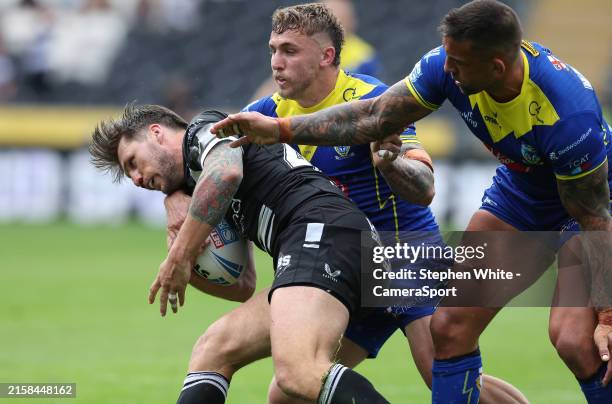 Hull FC's Tom Briscoe is tackled by Warrington Wolves' Sam Powell and Paul Vaughan during the Betfred Super League match between Hull FC and...