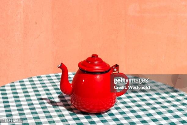red color tea kettle on table cloth at terrace - kettle stock pictures, royalty-free photos & images