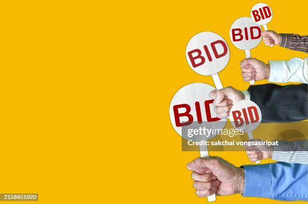businessman hold a bid sign - versteinerung stock-fotos und bilder