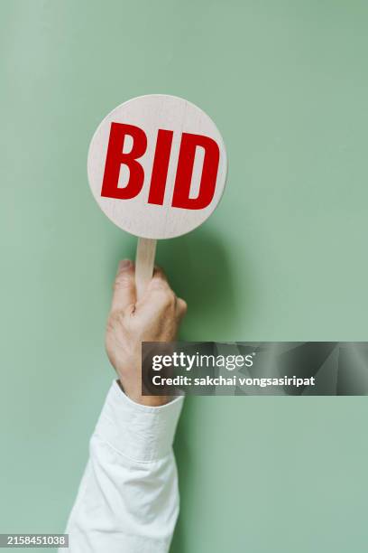 businessman hold a bid sign - gebot stock-fotos und bilder