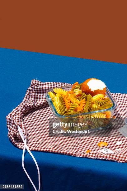 pasta kept in container with boiled egg over red checked bag - pasta salad stock pictures, royalty-free photos & images