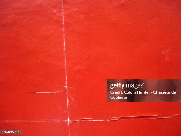close-up of empty and red posters stuck side by side on a textured wall in paris, france. sunlight and natural colors. - old poster stock pictures, royalty-free photos & images