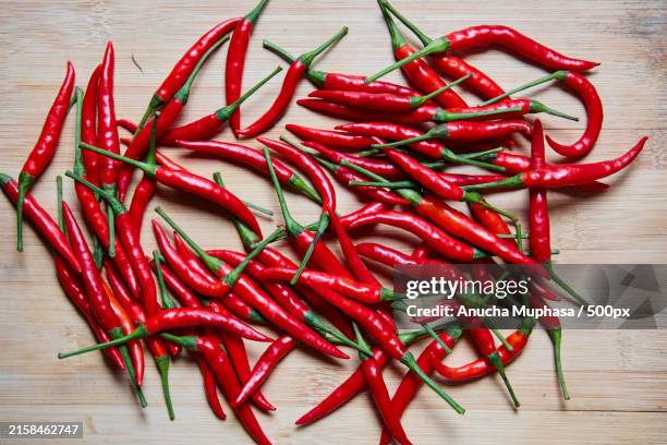 close-up of red chili peppers on table - cayenne pepper stock pictures, royalty-free photos & images