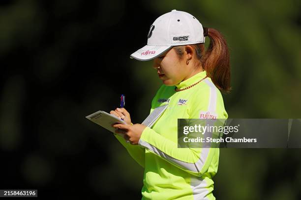 Ayaka Furue of Japan writes in her scorecard after making a birdie on the 11th hole during the first round of the KPMG Women's PGA Championship at...