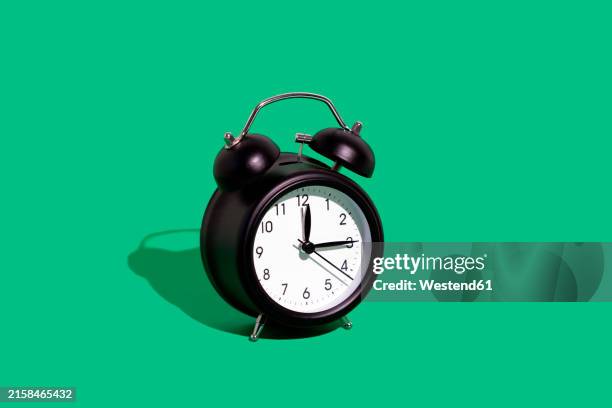 bildbanksillustrationer, clip art samt tecknat material och ikoner med retro alarm clock against green background - väckarklocka