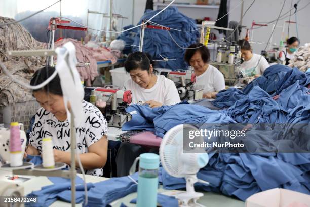 Worker of a cotton textile company is producing fabric products at a workshop in Binzhou, China, on June 24, 2024. At present, a variety of tooling,...