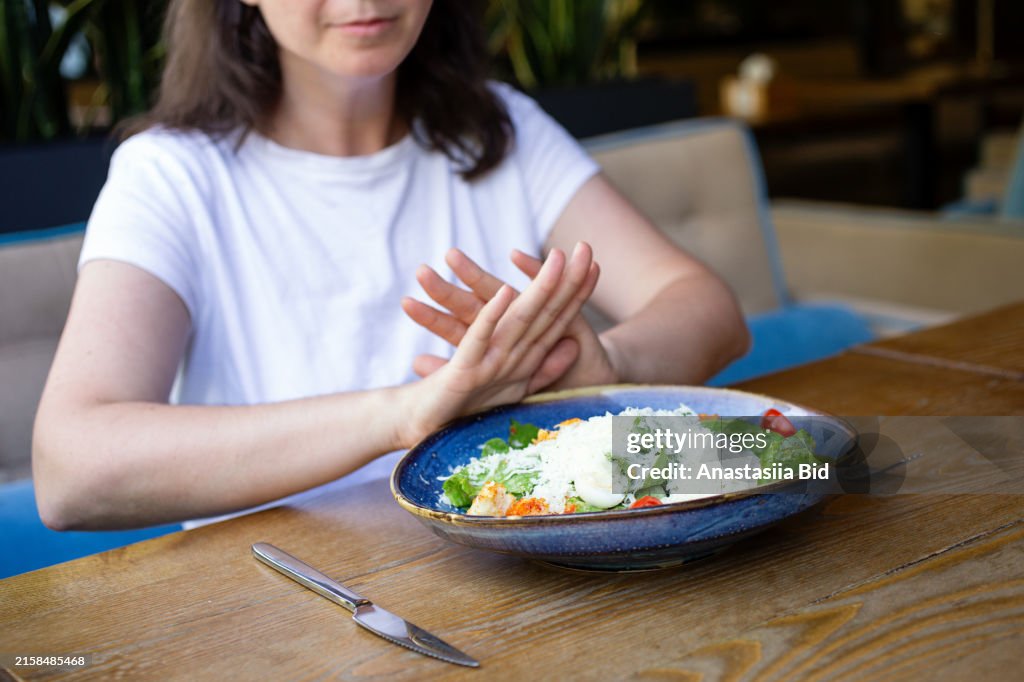 Anonymous woman refuses from food,concept of eating disorder. Stock photo.