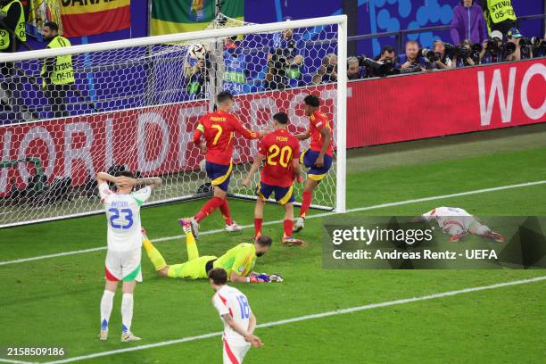 Riccardo Calafiori of Italy lies dejected on the gras after scoring an own goal and the first goal for Spain as Lamine Yamal, Alvaro Morata and Pedri...