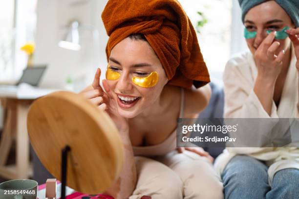 two young women, roommates, doing beauty routine at their shared apartment. - wrapped in a towel stock pictures, royalty-free photos & images