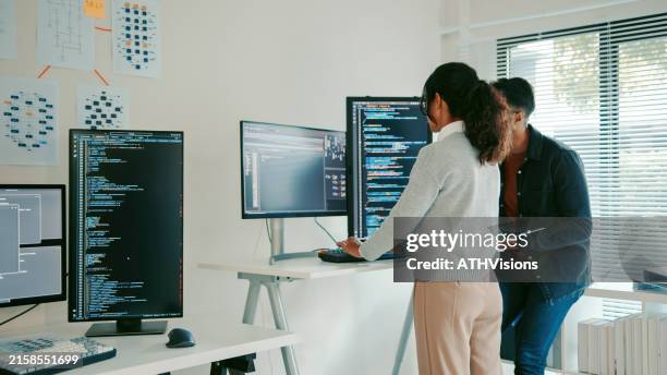 hispanic programmers reviewing code on laptop in modern office - computer bug stock pictures, royalty-free photos & images