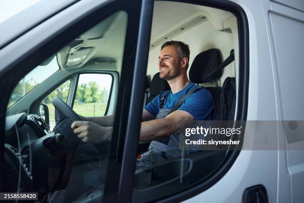 happy delivery man driving a van. - overall stockfoto's en -beelden