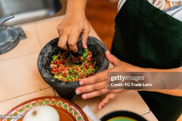 nahaufnahme einer frau, die guacamole in der küche zu hause zubereitet - guacamole stock-fotos und bilder