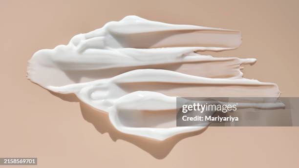 texture of cosmetic white cream on a delicate peach background. swatch of a cosmetic product. - amostra de cor imagens e fotografias de stock