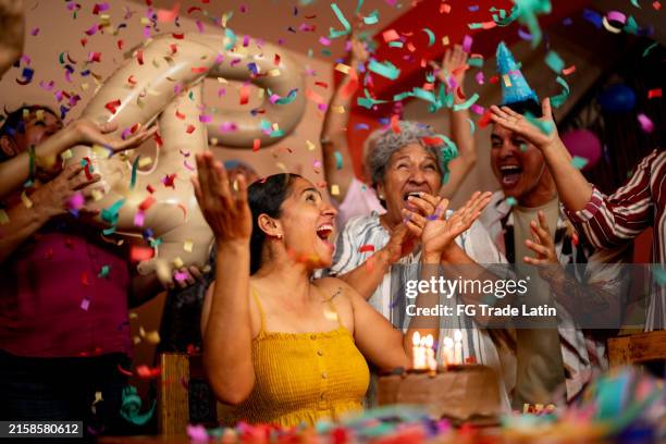 mature woman celebrating birthday with family at home - latin american and hispanic people stock pictures, royalty-free photos & images