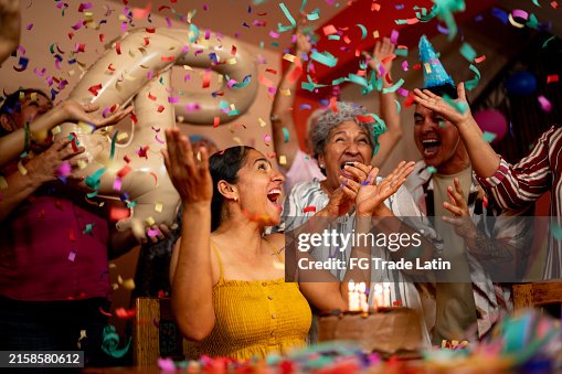Mature woman celebrating birthday with family at home Mature woman celebrating birthday with family at home