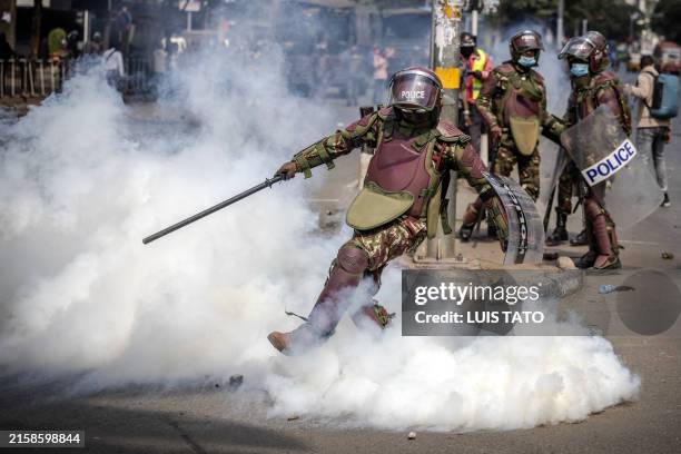 Kenya Police officer kicks a tear gas canister during a nationwide strike to protest against tax hikes and the Finance Bill 2024 in downtown Nairobi,...