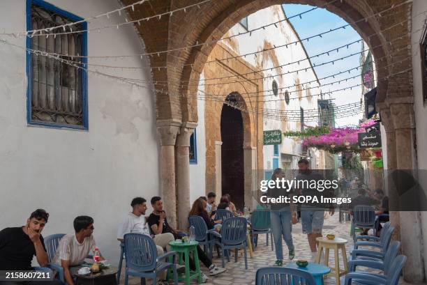 Young Tunisians and tourists enjoy the café culture in the alleyways of Tunis Medina, the historical quarter of Tunisian capital, Tunisia, North...