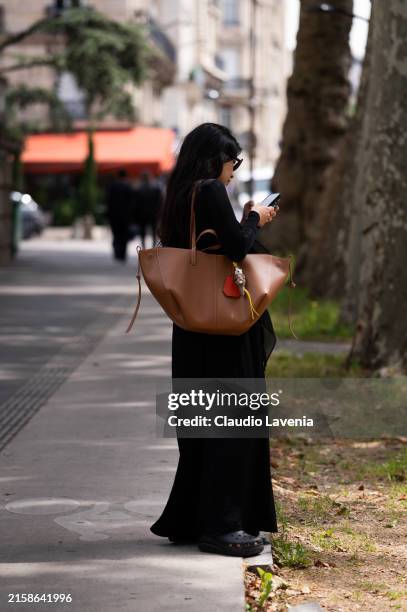 Guest wears long black dress, camel big bag, outside Rick Owens, during the Haute Menswear Spring/Summer 2025 as part of Paris Fashion Week on June...