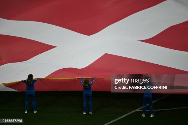 Flag bearers hold a giant Denmark's flag before the start of the UEFA Euro 2024 Group C football match between Denmark and Serbia at the Munich...