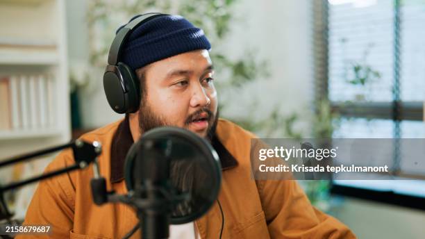 attractive young hispanic man is a pro in the broadcast biz! in studio, podcast article about ai to audience . - locutor-de-rádio imagens e fotografias de stock