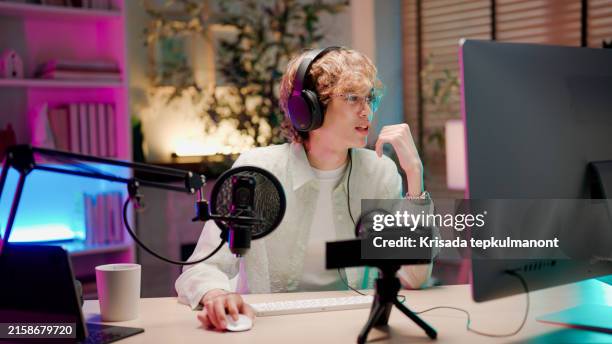 young asian man having conversation with her listener while holding a podcast session. - live streaming stock pictures, royalty-free photos & images