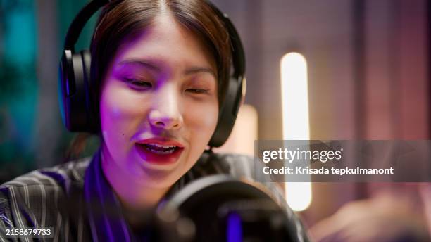 young asian woman sharing life experience with audience while holding a live podcast. - media interview stock pictures, royalty-free photos & images