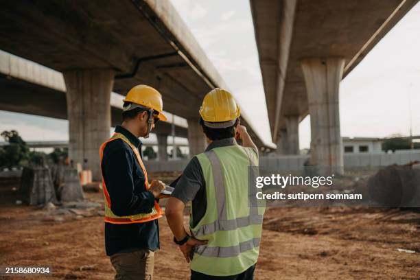 two men in construction gear are standing next to each other - capataz fotografías e imágenes de stock