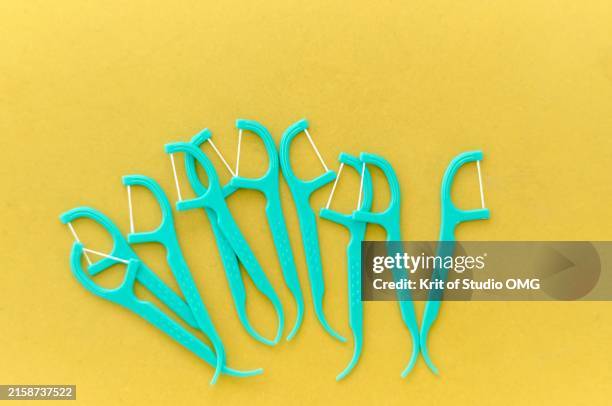 dental floss picks on yellow background - toothpick stock pictures, royalty-free photos & images