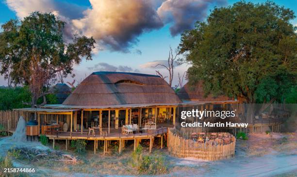 aerial view of the entertainment, reception and dining area with fire pit at an exclusive luxury tented safari lodge, botswana - safari lodge stock pictures, royalty-free photos & images