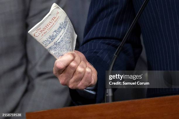 Rep. Ben Cline holds up a copy of the U.S. Constitution that he carries with him while he speaks during a press conference on Capitol Hill on June...