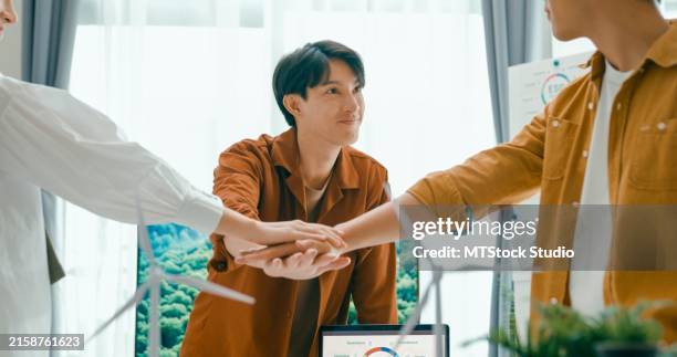 diverse team unites hands over desk with renewable energy models, symbolizing cooperation and agreement on sustainable business practices.eco-friendly business team discussing esg goals. - morality stock pictures, royalty-free photos & images