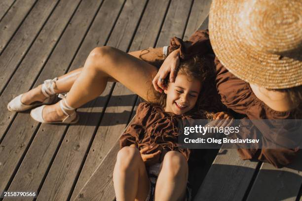 mom and daughter having fun outdoors in summer sunshine. harmony in family, happy childhood. - fashionable mom stock pictures, royalty-free photos & images