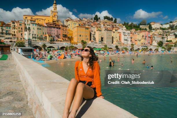 woman walking in menton during her vacation in french riviera - uferpromenade stock-fotos und bilder