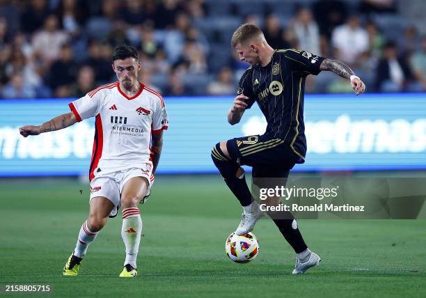 Mateusz Bogusz of Los Angeles FC controls the ball against Paul Marie of San Jose Earthquakes in the first half at BMO Stadium on June 22, 2024 in...