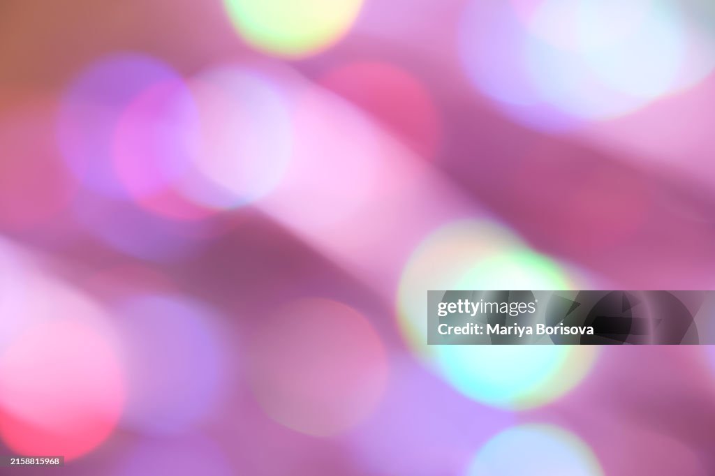 Festive abstract background with shining bokeh in pink and lilac shades. Perfect for birthdays and Christmas.