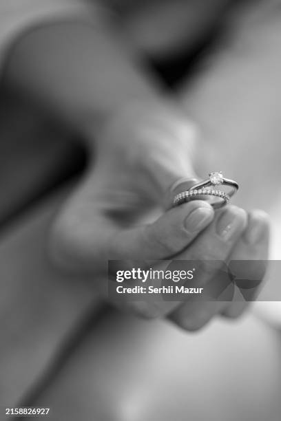 hand holds two wedding rings. wedding accessories, engagement rings. - diamond ring stock pictures, royalty-free photos & images