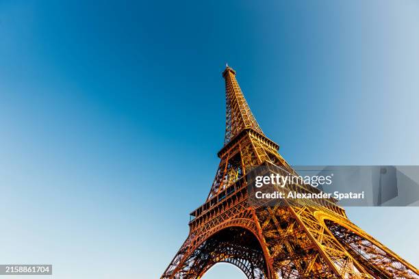 eiffel tower against clear blue sky, low angle view, paris, france - torre eiffel imagens e fotografias de stock